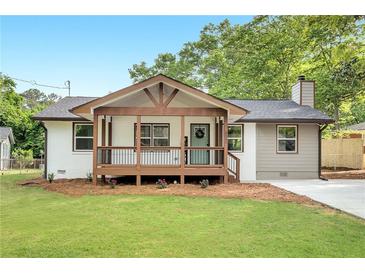 Charming renovated home featuring a welcoming porch, new siding, fresh paint, and a beautifully manicured front lawn at 2831 Ivanhoe Se Ln, Smyrna, GA 30082