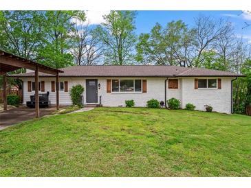 Charming brick home featuring well-maintained lawn, shutters and a covered carport at 605 Rocky Branch Rd, Villa Rica, GA 30180