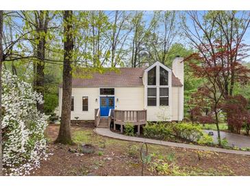 Charming single-Gathering home with a blue front door, surrounded by lush trees and landscaping at 3450 Brookhill Cir, Marietta, GA 30062