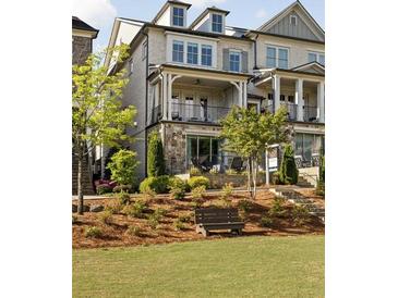 Charming townhouse featuring a front porch, balcony, and manicured lawn with a bench at 1129 Cordia Nw Ave, Atlanta, GA 30318