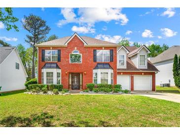 Beautiful two-story brick home with manicured lawn and two-car garage at 5147 Winding Glen Dr, Lithonia, GA 30038