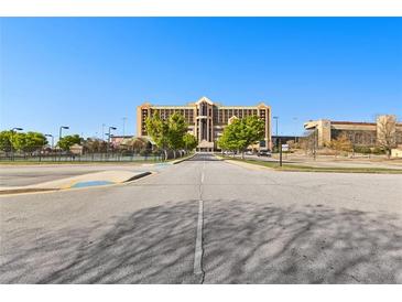 View of the building exterior with mature trees and parking area on a bright day at 1500 Tara Pl # 810, Hampton, GA 30228