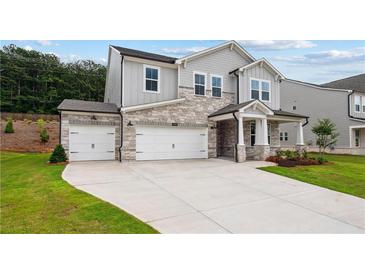 Charming two-story home with stone accents, a three-car garage and well-manicured front lawn at 719 Crossroad Ct, Powder Springs, GA 30127