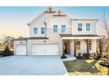 Beautiful two-story home with three-car garage, light brick, and professionally landscaped front yard at 719 Crossroad Ct, Powder Springs, GA 30127