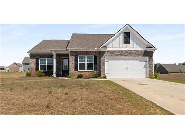 Charming brick home featuring stone accents, a two-car garage, and a well-manicured lawn at 1259 Fendt Dr, Locust Grove, GA 30248