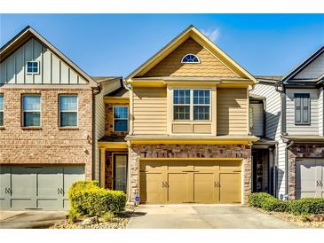 Charming two-story home features a well-maintained lawn and attached two-car garage at 2325 Thackery Rd, Snellville, GA 30078