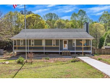 Charming single-story home with a welcoming front porch and landscaped yard at 507 Honeysuckle Ln, Woodstock, GA 30188