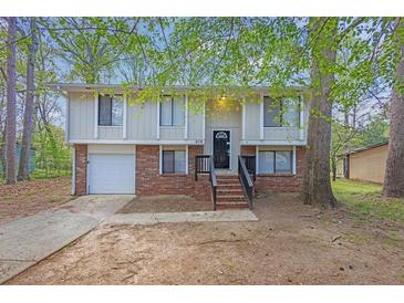 Two-story home featuring brick accents, light-colored siding, a dark front door, and a well-manicured front yard at 616 Country Lane Dr, Jonesboro, GA 30238