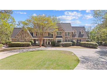 Stunning stone and siding home with lush landscaping and a circular driveway at 2839 Echols Rd, Cumming, GA 30041