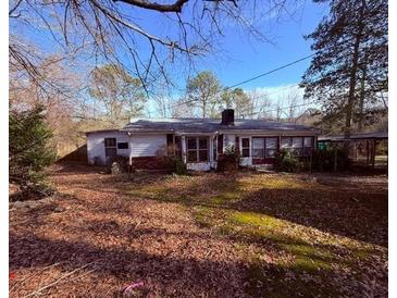 Charming ranch-style home with a welcoming porch, nestled on a wooded lot with mature trees at 214 S Lake Dr, Hiram, GA 30141