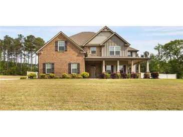 Two-story brick and siding home with a well-manicured lawn and covered front porch at 209 Brynn Ln, Mcdonough, GA 30252