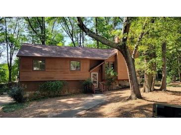 Charming house with wood siding, nestled among mature trees in a serene, wooded setting with stone foundation at 2763 Macby Walk, Marietta, GA 30066