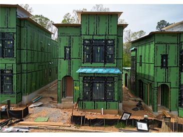 New construction exterior view showing modern design with black window frames and green sheathing at 11863 Serenbe Ln, Chattahoochee Hills, GA 30268