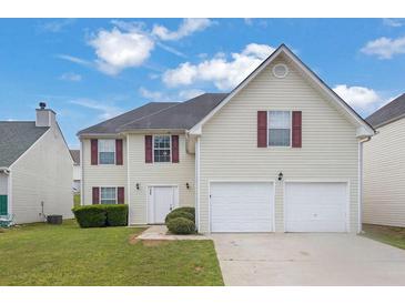 Two-story home featuring a two-car garage, vinyl siding, a well-maintained lawn, and inviting curb appeal at 3943 Brookgate Ct, Ellenwood, GA 30294