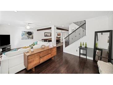 Open-concept living room with hardwood floors, a ceiling fan, white sofa, and seamless access to the dining area at 1152 Hampton Ne Way, Atlanta, GA 30324
