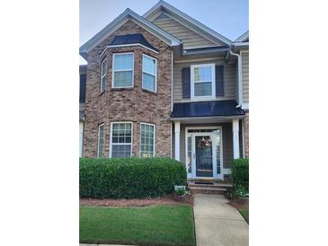 Charming two-story townhouse with brick facade and manicured landscaping at 5449 Festival Ave, Fairburn, GA 30213