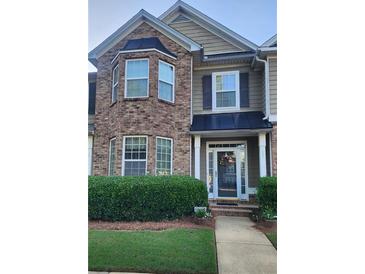 Charming townhome with brick facade, covered porch, and manicured landscaping at 5449 Festival Ave, Fairburn, GA 30213