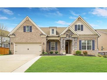 Charming brick home with a manicured lawn, attached garage and stone accents at 403 Aristides Way, Canton, GA 30115