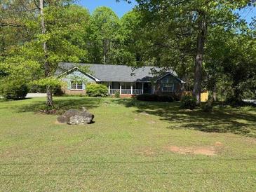 Ranch style home with covered porch, mature trees and a large front yard at 9214 Brave Ct, Jonesboro, GA 30236