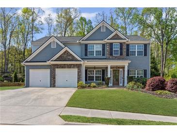 Charming two-story home with a three car garage and manicured lawn at 6655 Grove Meadows Ln, Cumming, GA 30028