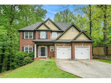 Charming two-story home with a brick facade, two-car garage, and well-manicured lawn and mature trees at 71 Anita Se Pl, Mableton, GA 30126