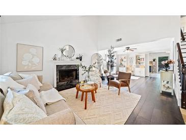 Bright living room with a fireplace, hardwood floors, and neutral decor offers a cozy and inviting space at 4009 Glenlake Nw Trce, Kennesaw, GA 30144