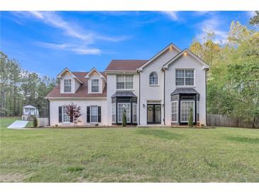 Charming two-story white brick home with manicured lawn and lovely landscaping at 3405 River Ridge, Stockbridge, GA 30281