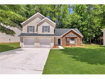 Charming two-story home with a two-car garage, stone accents and a well-manicured lawn at 3505 Oakshire Se Way, Atlanta, GA 30354