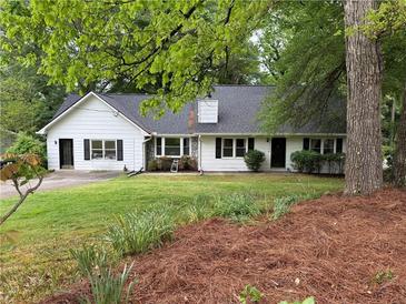 Charming one-story home with white siding, black shutters, and a well-manicured lawn at 3013 Barcelona Way, Conyers, GA 30012
