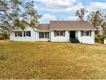 Charming single-story home with a brick exterior, dark shutters, and a well-manicured lawn at 1828 Kellogg Creek Rd, Acworth, GA 30102