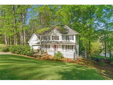 Charming two-story home with a welcoming front porch and beautifully landscaped front yard, surrounded by mature trees at 2210 Hamstead Ct, Suwanee, GA 30024