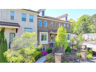 Beautiful brick townhome featuring manicured landscaping, brick stairs, and a charming front entrance at 4007 Dunwoody Trce, Atlanta, GA 30338