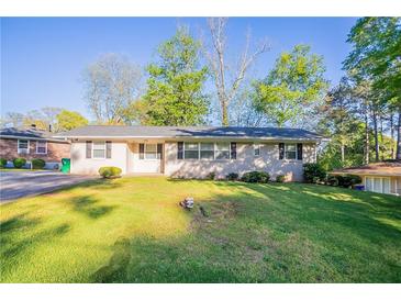 Charming single-story home with a well-maintained lawn, brick facade, and mature trees at 3905 Kirksford Dr, Decatur, GA 30035
