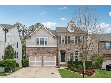 Charming two-story home features a brick and siding exterior, a two-car garage and manicured landscaping at 104 Marlow Dr, Woodstock, GA 30188
