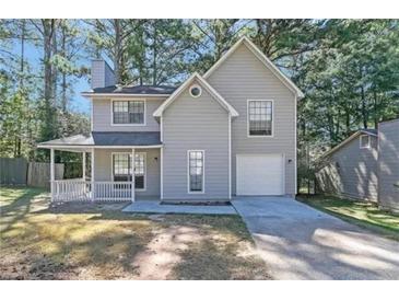 Charming two-story home with attached garage and inviting front porch; neutral siding blends with wooded surroundings at 772 Edenton Ct, Jonesboro, GA 30238