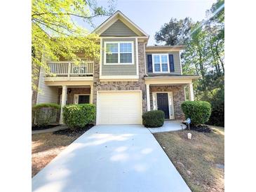 Charming townhome featuring a two-car garage, brick accents, and a cozy front porch at 2333 Castle Keep Way, Atlanta, GA 30316