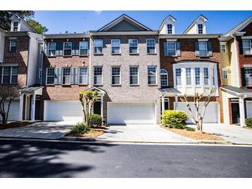 A brick townhome featuring a two-car garage and neutral paint at 2928 Wintercrest Way, Atlanta, GA 30360