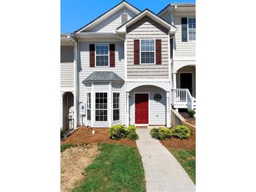 Charming townhome featuring a red front door, bay window, and well-maintained landscaping at 73 Timber Ridge Dr, Cartersville, GA 30121