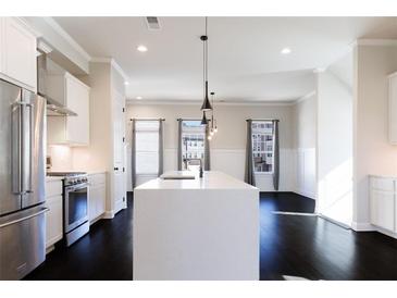Bright kitchen features a center island, stainless steel appliances, dark hardwood floors, and recessed lighting at 1110 Bakary Ct, Decatur, GA 30032
