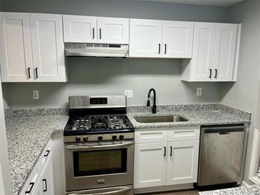 Updated kitchen with white cabinets, stainless steel appliances, and granite countertops at 907 River Run Dr, Atlanta, GA 30350