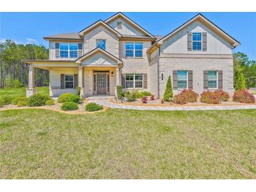 Elegant brick home with manicured lawn, covered porch, and charming landscaping at 125 Leverett Ct, Fayetteville, GA 30215