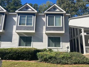Attractive two-story townhome featuring bay windows, neutral siding, and mature landscaping at 25 Fair Haven Way, Smyrna, GA 30080