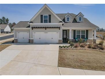 Charming home featuring a three-car garage, a combination of stone and siding accents, with a well-manicured lawn at 15 Masters Dr, Villa Rica, GA 30180
