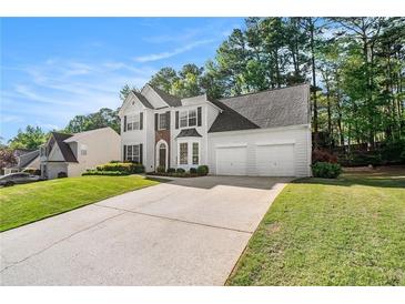 Charming two-story home with a well-manicured lawn, two car garage and elegant architectural details at 1916 Oakwood Grove Dr, Snellville, GA 30078