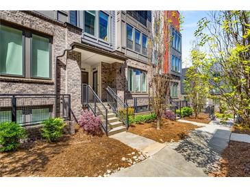 Beautiful townhome showcases brick facade, landscaped front yard, and inviting entryway with steps at 383 Pratt Se Dr # 504, Atlanta, GA 30315