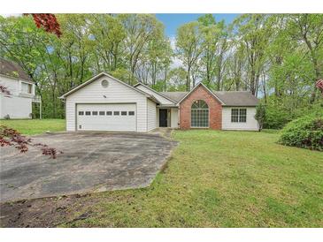 Charming single-story home with a two-car garage, brick accent, and a well-maintained front lawn at 3719 Bomar Rd, Douglasville, GA 30135