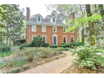Charming two-story brick home featuring a landscaped yard and a brick walkway leading to the front door at 5884 Hammersmith Rd, Stone Mountain, GA 30087