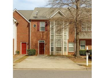 Two-story brick townhome with a front yard and driveway, showcasing its classic architectural details at 7112 Brookview Way, Riverdale, GA 30274
