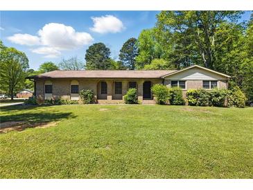 Charming brick home featuring a well-manicured lawn and mature trees at 2846 Spring Lake Dr, Buford, GA 30519