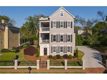 Charming three-story home features black window shutters, dual balconies and a manicured front yard at 3890 The Battery, Duluth, GA 30096